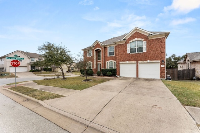 view of front of house with driveway, brick siding, an attached garage, and fence