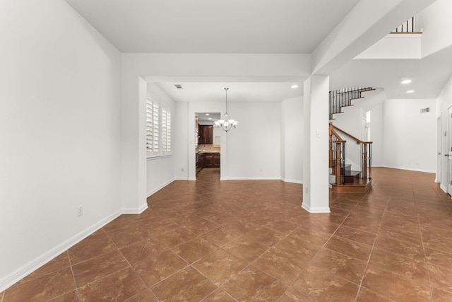 unfurnished room featuring baseboards, stairway, and an inviting chandelier