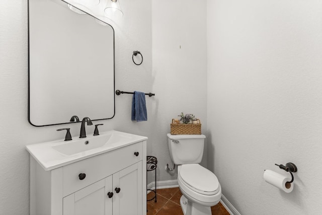 bathroom featuring baseboards, vanity, toilet, and tile patterned floors