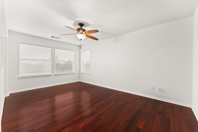 empty room with a ceiling fan, baseboards, visible vents, and wood finished floors