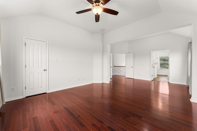 unfurnished room featuring baseboards, visible vents, vaulted ceiling, and wood finished floors