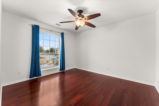 unfurnished room featuring ceiling fan, dark wood finished floors, visible vents, and baseboards