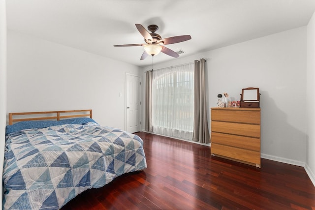 bedroom featuring a ceiling fan, visible vents, baseboards, and wood finished floors