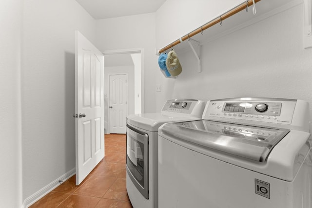 laundry area featuring laundry area, light tile patterned floors, baseboards, and washer and clothes dryer