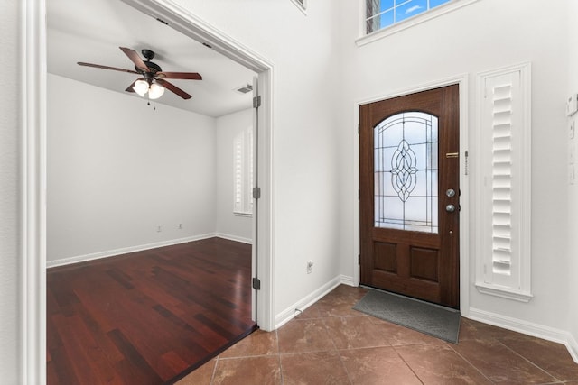 entryway featuring visible vents, wood finished floors, a ceiling fan, and baseboards