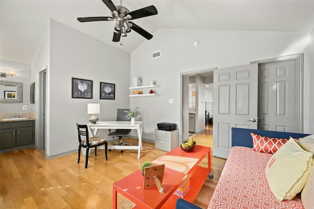 interior space featuring a ceiling fan, light wood-type flooring, visible vents, and vaulted ceiling