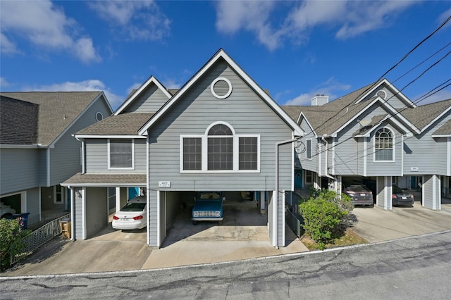 multi unit property with a carport and roof with shingles