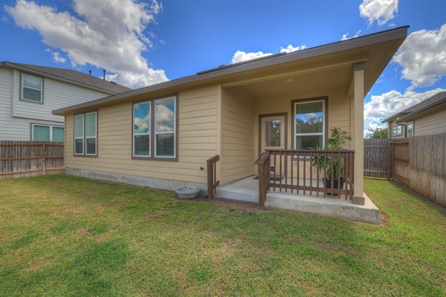 back of property featuring a fenced backyard, a lawn, and a patio