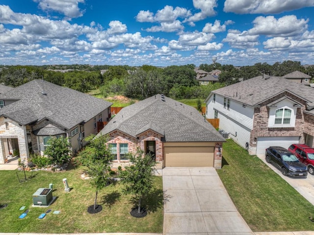 view of front of house with a shingled roof, concrete driveway, brick siding, and a front lawn