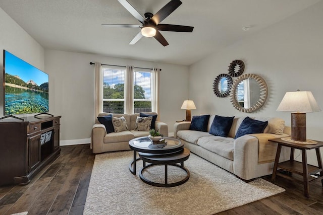 living area featuring a ceiling fan, baseboards, and dark wood-style flooring