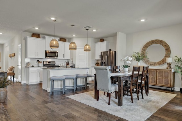 dining room featuring dark wood-style floors, baseboards, visible vents, and recessed lighting