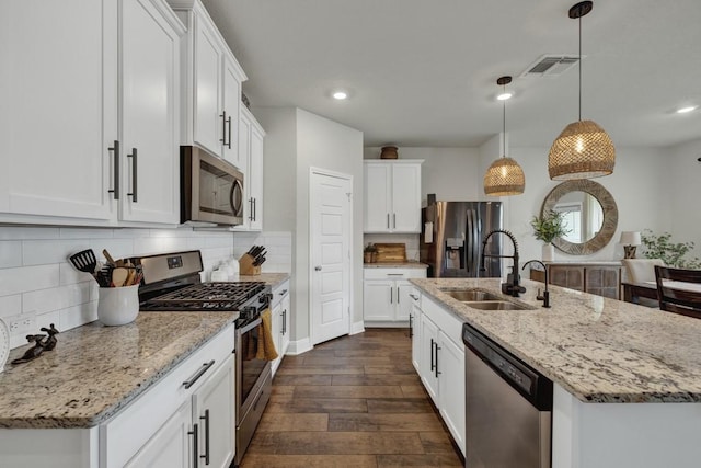 kitchen with backsplash, appliances with stainless steel finishes, dark wood-style flooring, and a sink