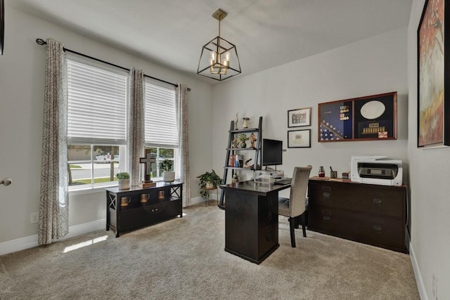 carpeted home office featuring a chandelier and baseboards