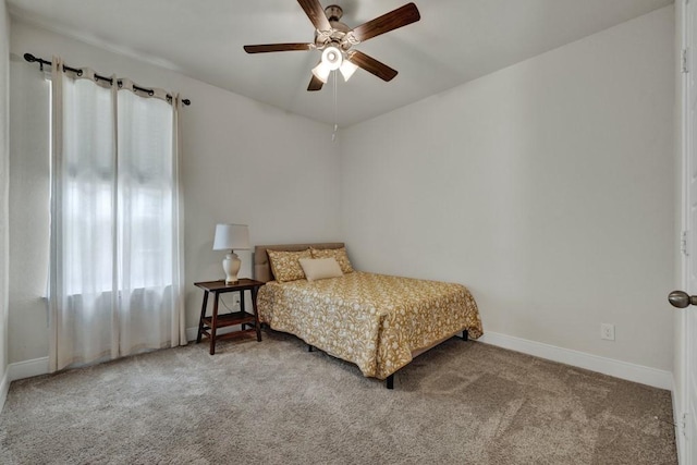 carpeted bedroom with ceiling fan and baseboards