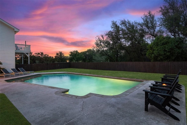 pool at dusk featuring a lawn, a patio area, a fenced backyard, and a fenced in pool