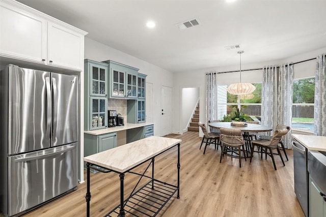 kitchen with visible vents, light countertops, light wood-type flooring, and freestanding refrigerator