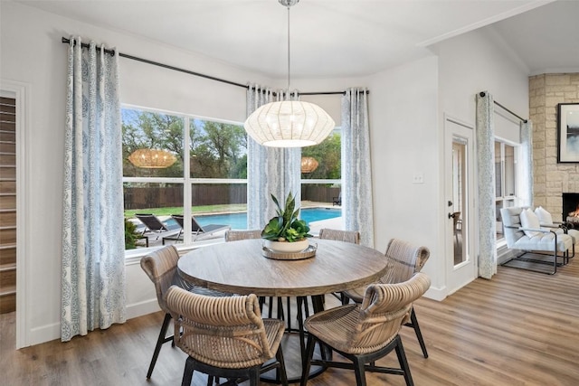 dining room featuring plenty of natural light, a fireplace, and wood finished floors