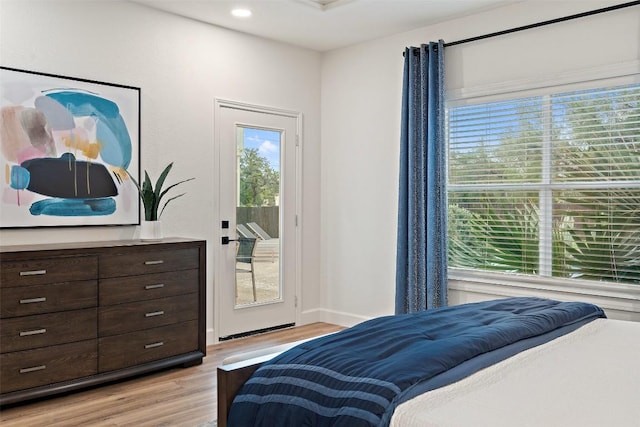 bedroom featuring access to exterior, light wood-style flooring, baseboards, and recessed lighting