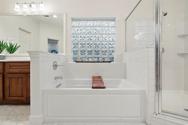 bathroom featuring a stall shower, marble finish floor, a bath, and vanity