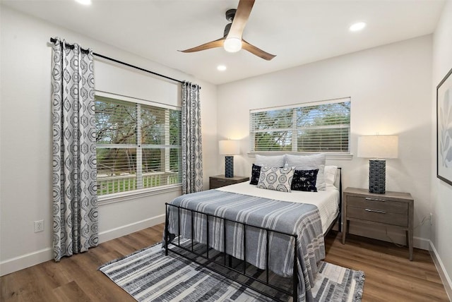 bedroom featuring multiple windows, baseboards, wood finished floors, and recessed lighting