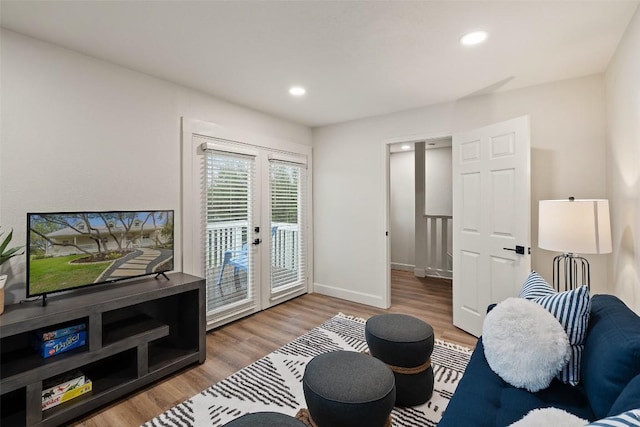 living area with recessed lighting, baseboards, and wood finished floors