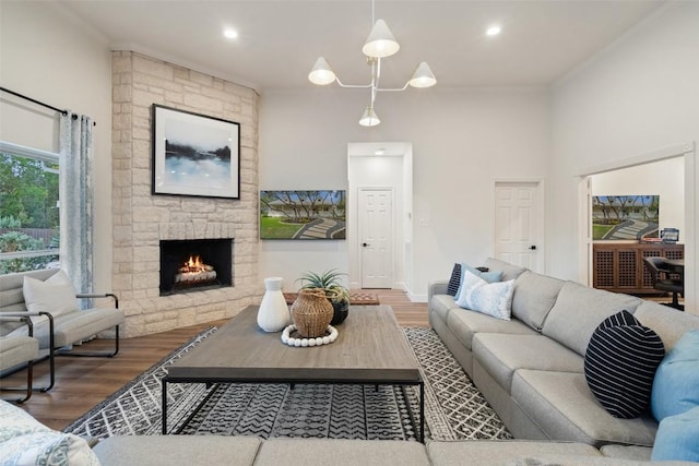 living room featuring recessed lighting, wood finished floors, and a stone fireplace