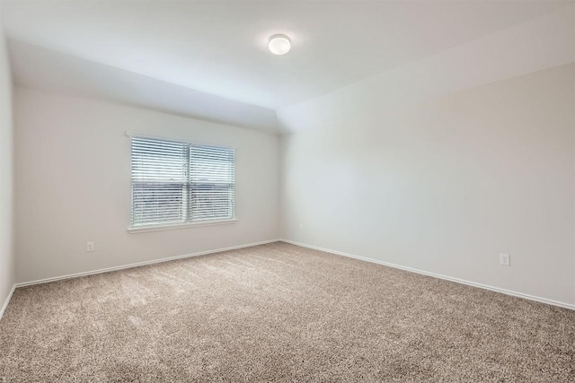 spare room featuring carpet and baseboards