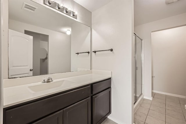 bathroom with a stall shower, tile patterned flooring, visible vents, and vanity