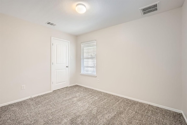 carpeted empty room featuring visible vents and baseboards