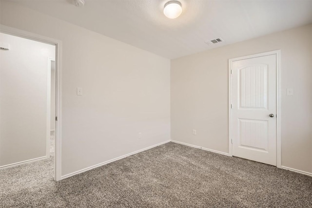 carpeted empty room featuring visible vents and baseboards