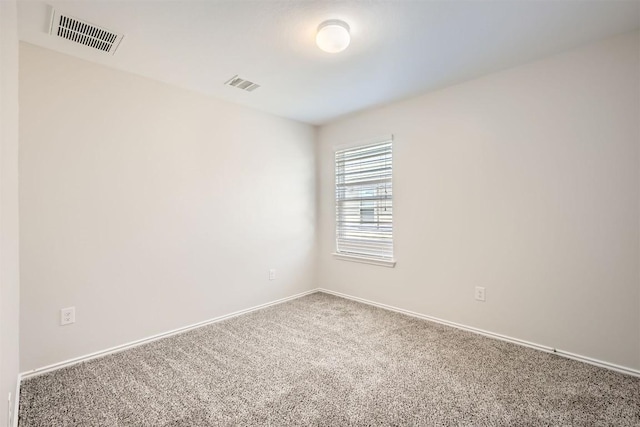 carpeted spare room with baseboards and visible vents