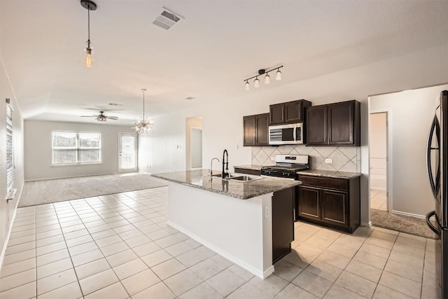 kitchen featuring light tile patterned flooring, a sink, visible vents, appliances with stainless steel finishes, and decorative backsplash