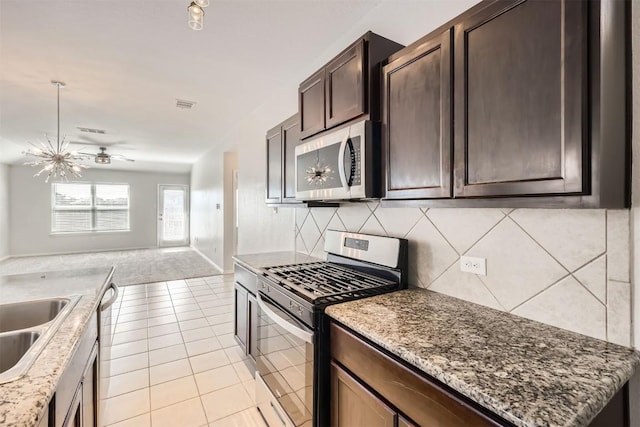 kitchen with light tile patterned floors, tasteful backsplash, open floor plan, stainless steel appliances, and dark brown cabinets