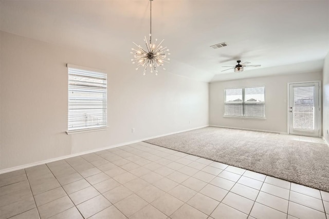 unfurnished room featuring light tile patterned flooring, light colored carpet, ceiling fan with notable chandelier, visible vents, and baseboards