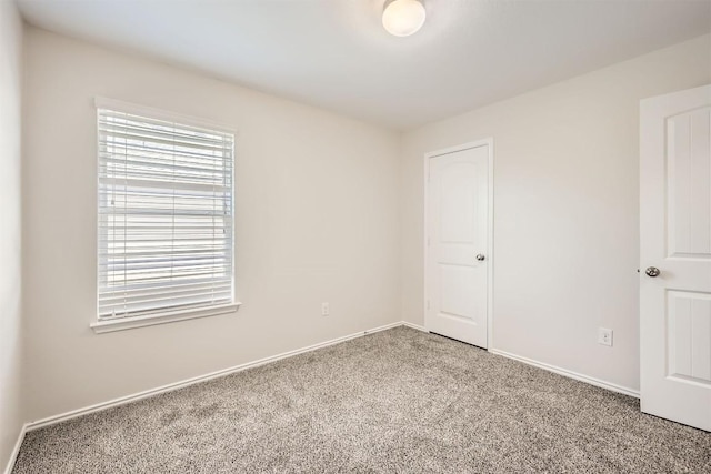 carpeted empty room with baseboards