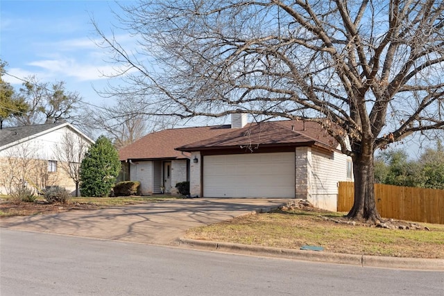 ranch-style house featuring an attached garage, fence, driveway, roof with shingles, and a chimney