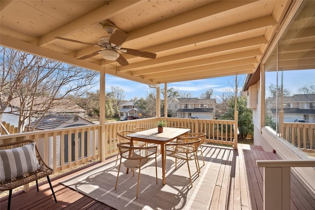 deck featuring outdoor dining space, a residential view, and a ceiling fan