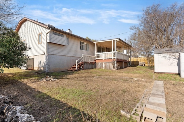 rear view of house with stairway, a chimney, a wooden deck, and a lawn