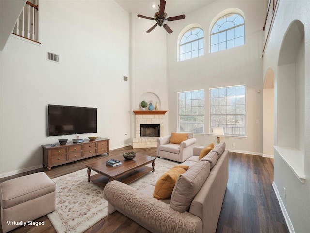 living area with baseboards, a fireplace, visible vents, and wood finished floors