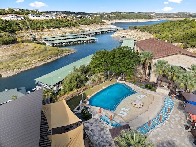 pool featuring a water view, a patio area, and fence