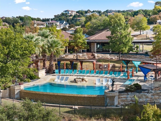 community pool with a patio and fence