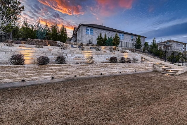 yard at dusk featuring stairs