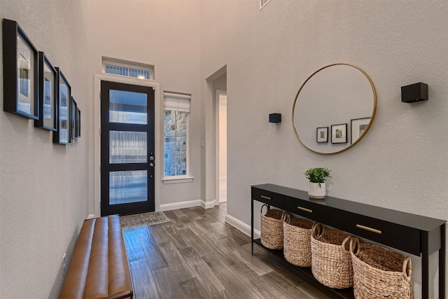 foyer featuring dark wood-type flooring and baseboards