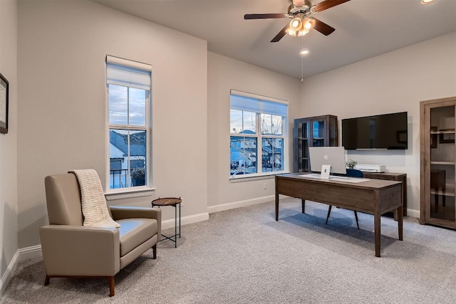 office space featuring light carpet, ceiling fan, and baseboards