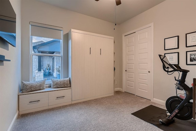 exercise area featuring light carpet, ceiling fan, and baseboards