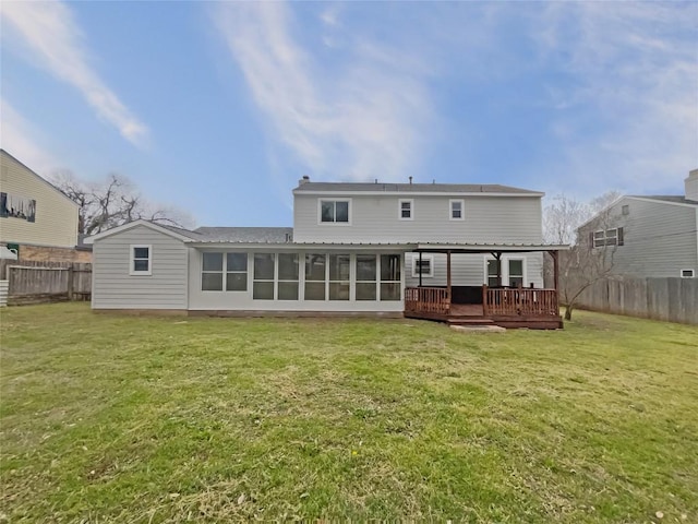 back of property featuring a sunroom, fence, and a lawn