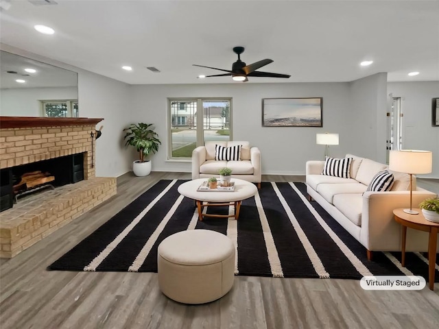 living room with a fireplace, wood finished floors, a ceiling fan, and recessed lighting