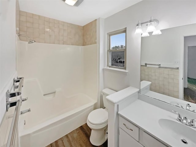 bathroom with tile walls, toilet, tub / shower combination, vanity, and wood finished floors