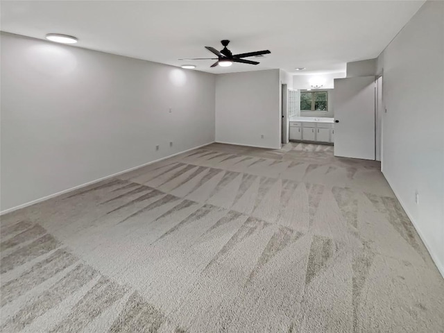 unfurnished living room with carpet floors, ceiling fan, and baseboards