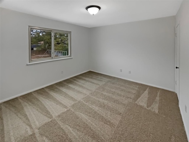 carpeted empty room with baseboards